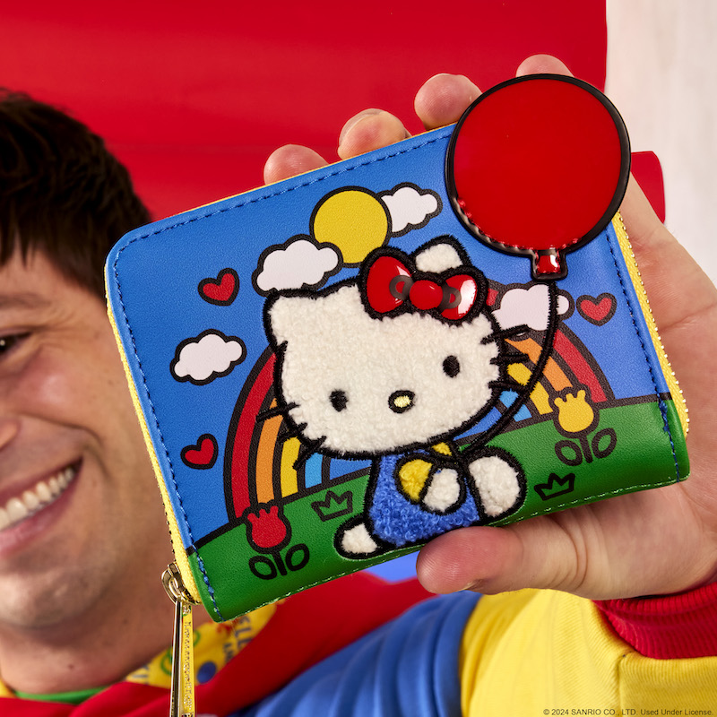Man holding the Loungefly Sanrio Hello Kitty 50th Anniversary Zip Around Wallet toward the camera 